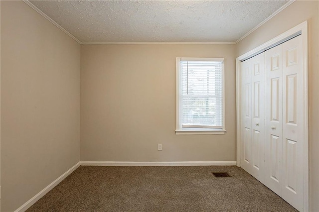 unfurnished bedroom with carpet, ornamental molding, a textured ceiling, and a closet