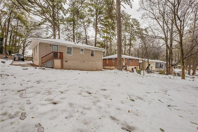 view of snow covered back of property