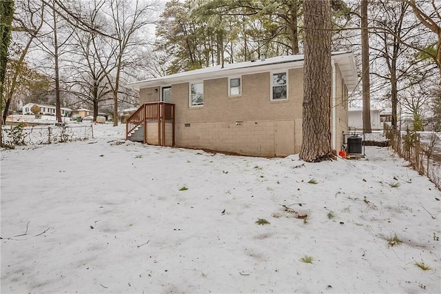 snow covered property with cooling unit