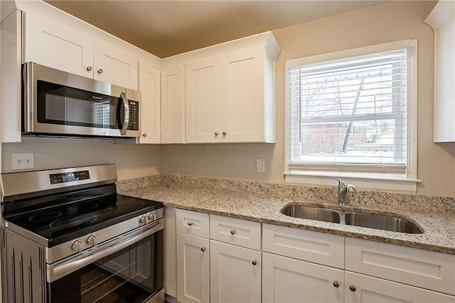 kitchen featuring a healthy amount of sunlight, white cabinetry, sink, and appliances with stainless steel finishes