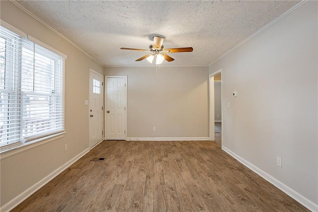 unfurnished room featuring ceiling fan, crown molding, light hardwood / wood-style floors, and a textured ceiling