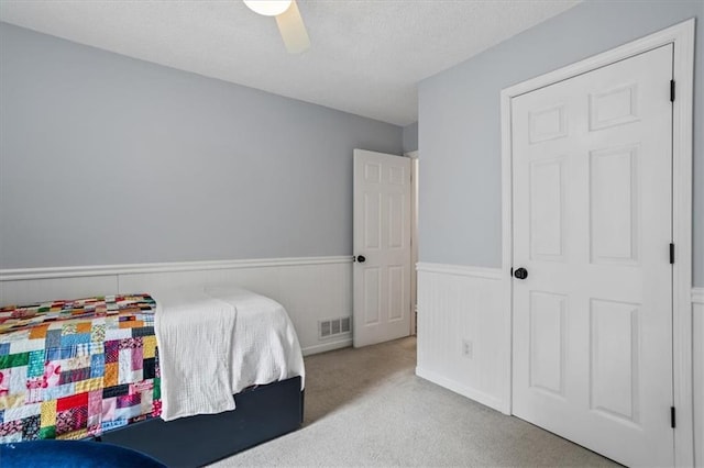 4255 Hidden Meadow Cir, Sugar Hill, GA 30518 - bedroom with wainscoting, carpet flooring, a textured ceiling, and a ceiling fan