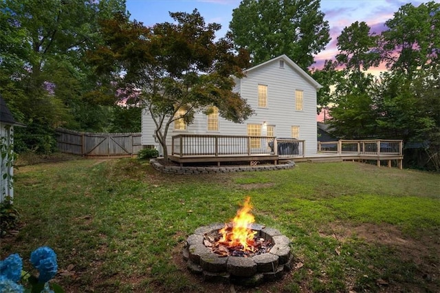4255 Hidden Meadow Cir, Sugar Hill, GA 30518 - back of house at dusk with an outdoor fire pit, a deck, and a gate