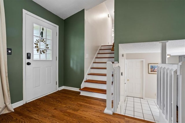4255 Hidden Meadow Cir, Sugar Hill, GA 30518 - foyer entrance with a textured ceiling, wood finished floors, baseboards, and stairs
