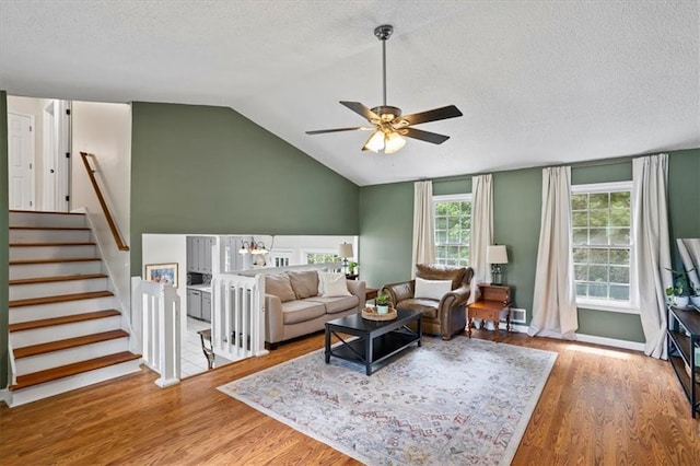 4255 Hidden Meadow Cir, Sugar Hill, GA 30518 - living room with ceiling fan, a textured ceiling, wood finished floors, vaulted ceiling, and stairway