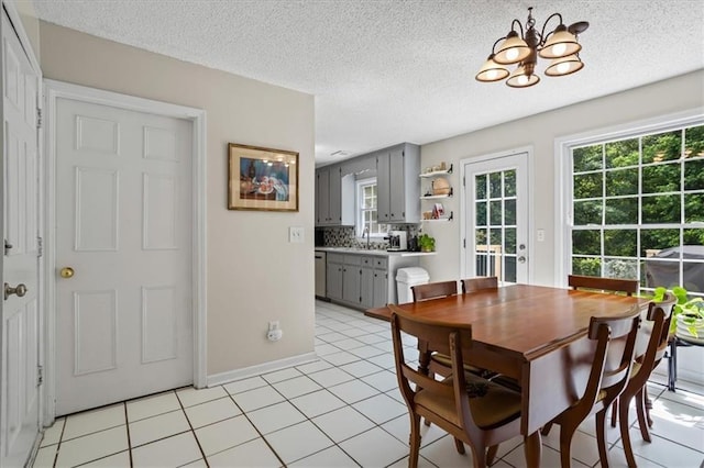 4255 Hidden Meadow Cir, Sugar Hill, GA 30518 - dining room with a chandelier, plenty of natural light, light tile patterned flooring, a textured ceiling, and baseboards
