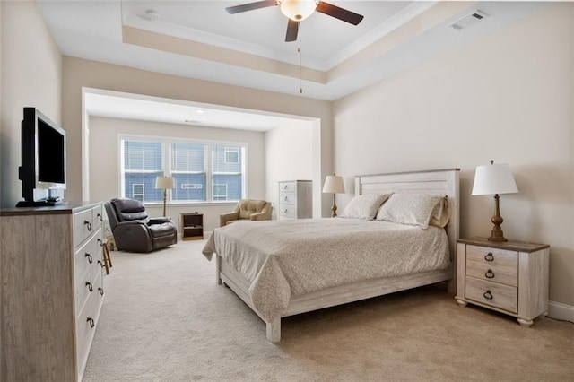 bedroom featuring light carpet, a raised ceiling, and ceiling fan