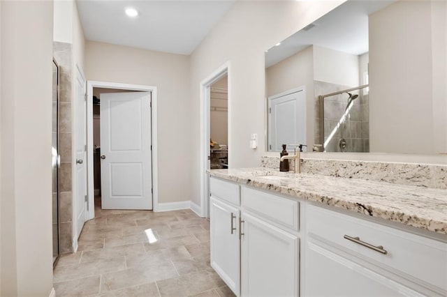 bathroom featuring a shower with door and vanity