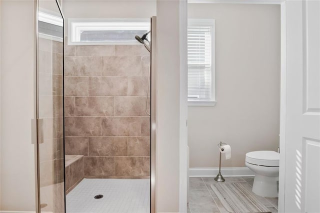 bathroom with toilet, a shower with shower door, and tile patterned flooring