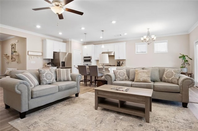 living room featuring light hardwood / wood-style floors, crown molding, and ceiling fan with notable chandelier