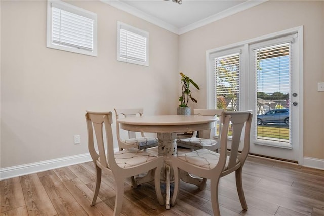 dining space featuring crown molding and light wood-type flooring