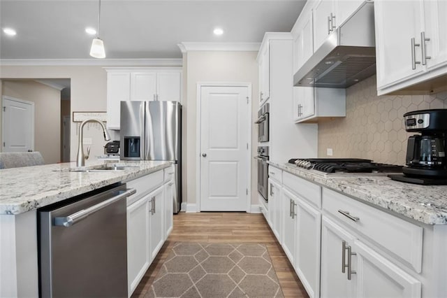 kitchen with sink, white cabinets, decorative light fixtures, appliances with stainless steel finishes, and light hardwood / wood-style floors