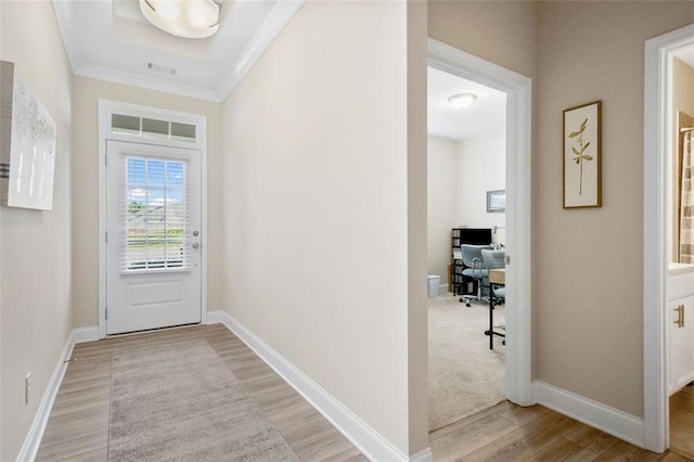 doorway to outside with crown molding and light hardwood / wood-style floors