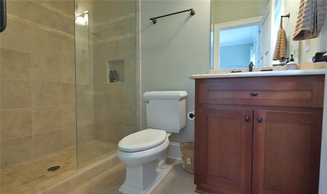 bathroom with vanity, tiled shower, and toilet