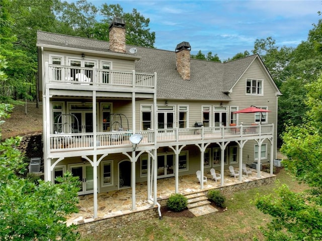 back of property with a patio area, a balcony, and a deck