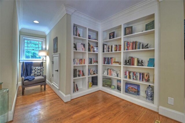 living area featuring crown molding and wood-type flooring