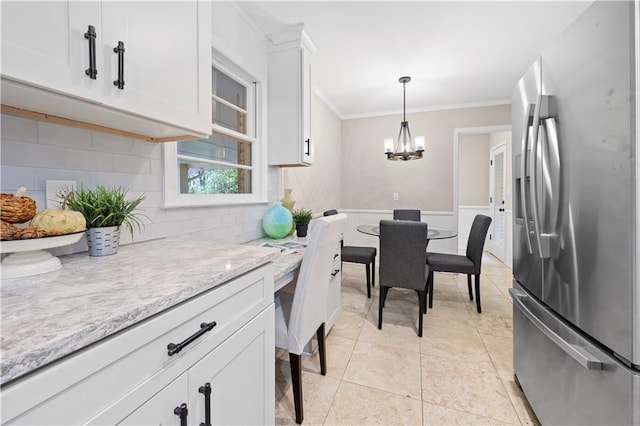 kitchen featuring pendant lighting, white cabinetry, decorative backsplash, stainless steel fridge with ice dispenser, and light stone countertops