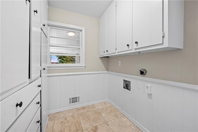 clothes washing area with cabinets, washer hookup, and light tile patterned floors