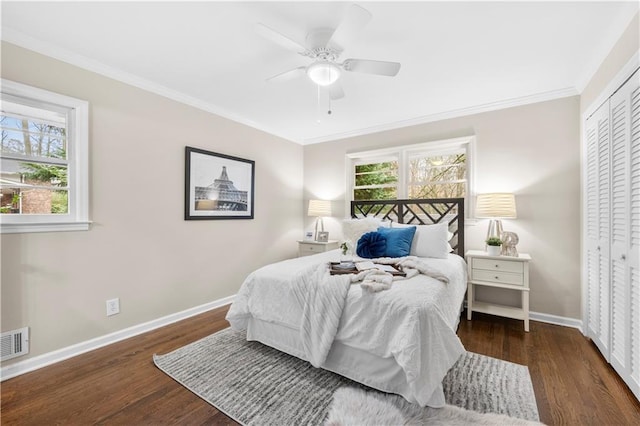 bedroom with dark hardwood / wood-style flooring, ornamental molding, and a closet