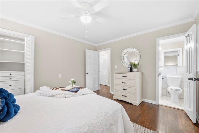 bedroom featuring connected bathroom, ornamental molding, ceiling fan, dark wood-type flooring, and a closet