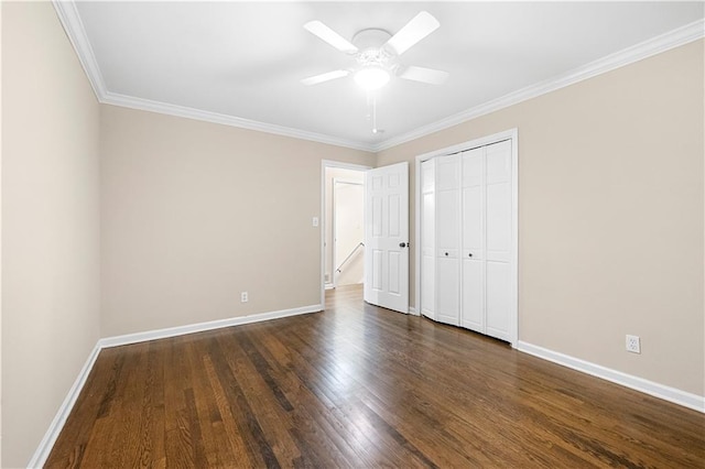 unfurnished bedroom with crown molding, ceiling fan, dark hardwood / wood-style flooring, and a closet