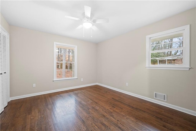 unfurnished room with plenty of natural light, dark hardwood / wood-style floors, and ceiling fan