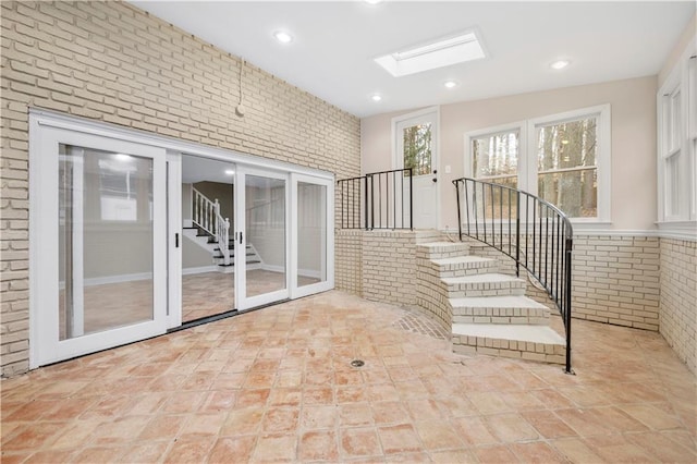 interior space with brick wall and a skylight