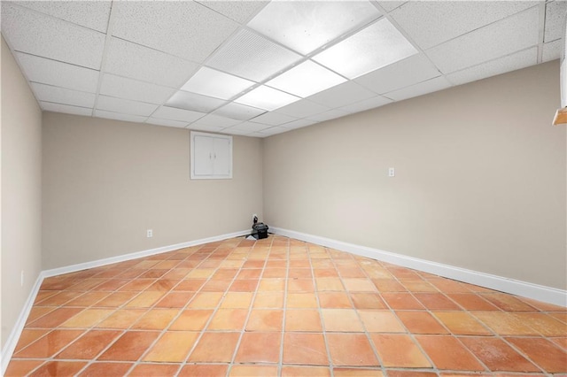 basement featuring tile patterned flooring and a paneled ceiling