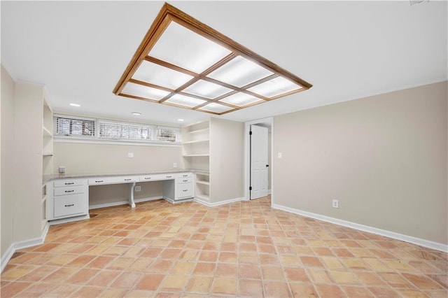 unfurnished office featuring light tile patterned floors and built in desk