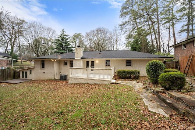 rear view of house featuring cooling unit, a patio, a wooden deck, and a lawn