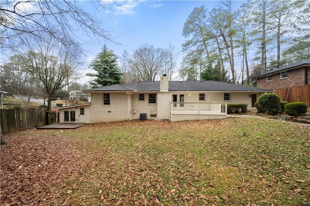 back of property with a wooden deck, a patio area, central AC, and a lawn