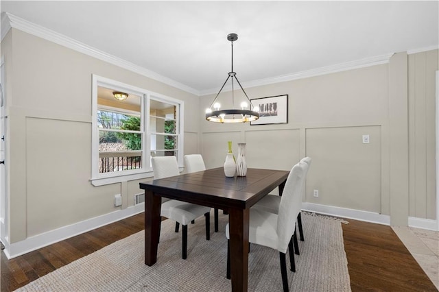 dining room featuring crown molding, dark hardwood / wood-style floors, and an inviting chandelier
