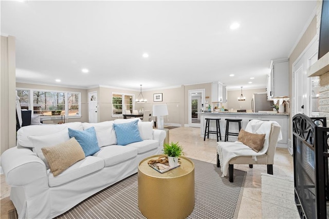 living room featuring a notable chandelier, crown molding, and light tile patterned flooring