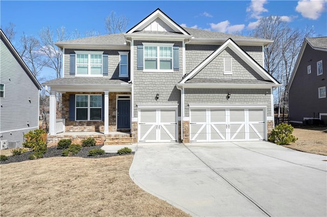 craftsman-style home with stone siding, an attached garage, and driveway