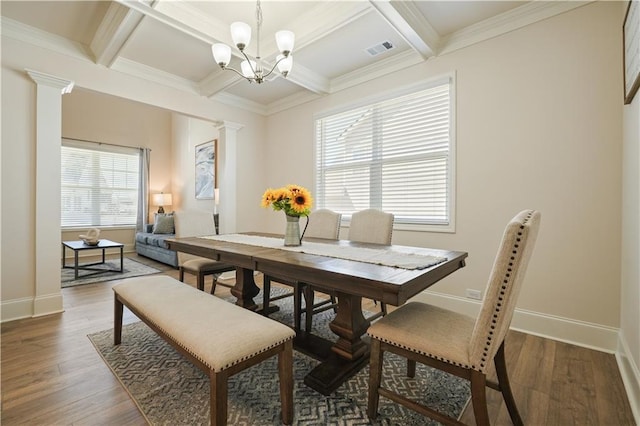 dining room featuring visible vents, baseboards, wood finished floors, and ornate columns