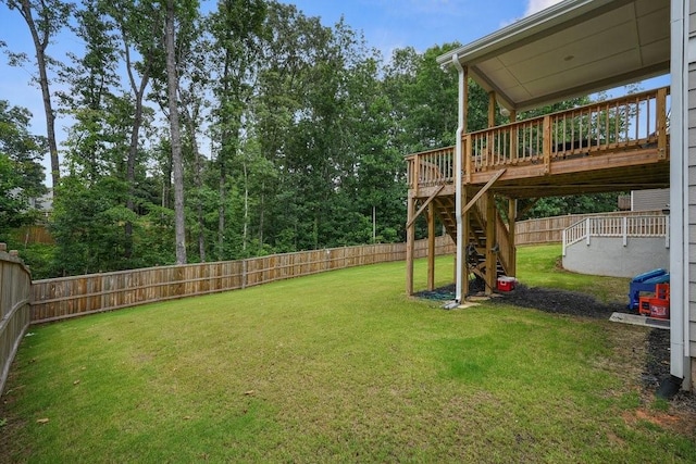 view of yard featuring a deck, stairway, and a fenced backyard