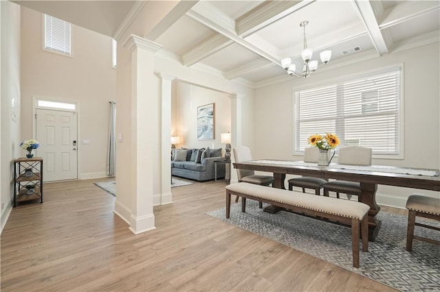 dining room with a notable chandelier, decorative columns, visible vents, and light wood-type flooring