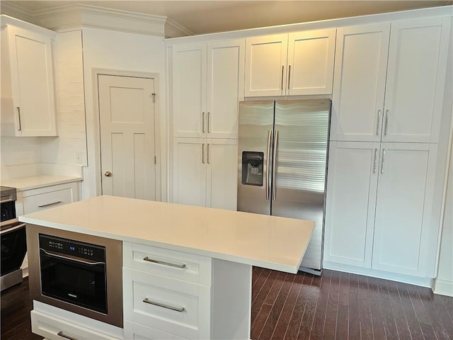 kitchen featuring dark wood-type flooring, white cabinetry, ornamental molding, and stainless steel refrigerator with ice dispenser