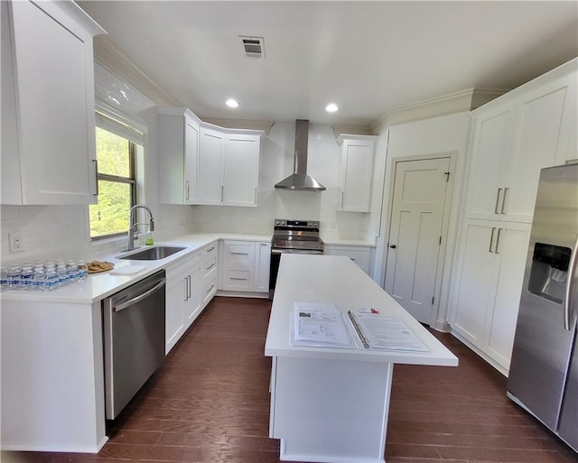 kitchen with wall chimney range hood, appliances with stainless steel finishes, dark hardwood / wood-style floors, sink, and a center island