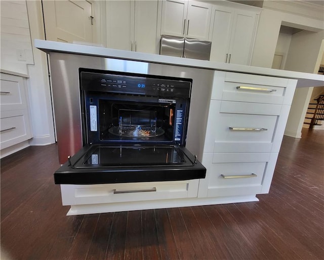 interior details with white cabinetry and dark hardwood / wood-style flooring