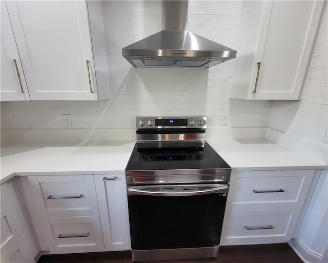 kitchen featuring white cabinetry, wall chimney exhaust hood, and electric range