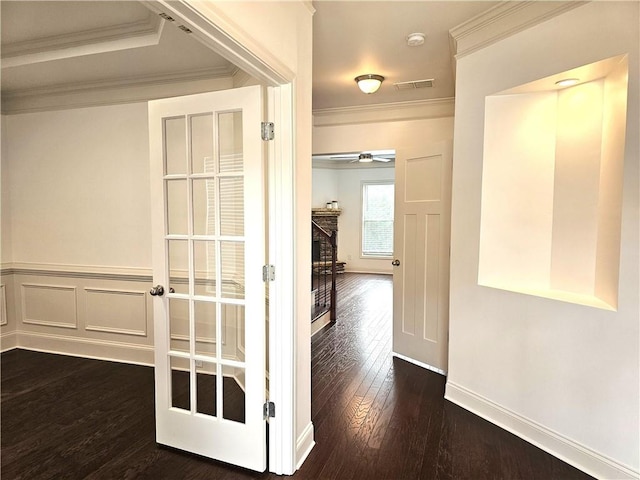 corridor with dark wood-type flooring and ornamental molding