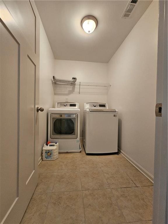 laundry room with light tile patterned floors and washing machine and clothes dryer