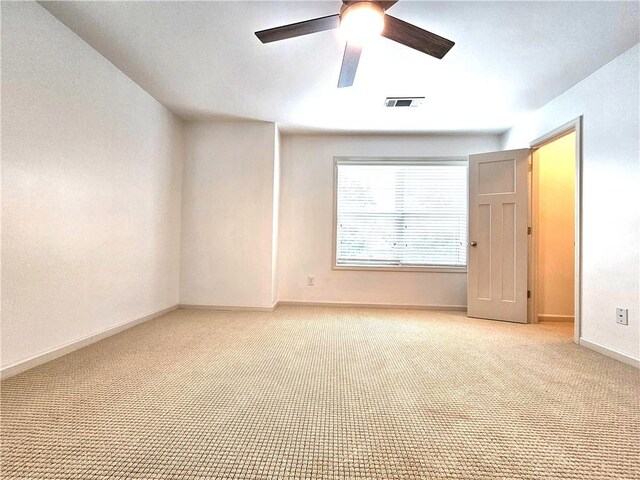 empty room featuring light colored carpet and ceiling fan