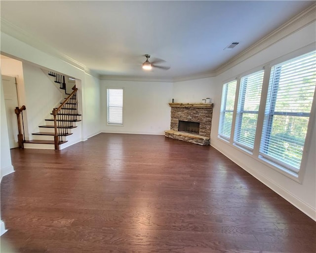 unfurnished living room with a stone fireplace, ornamental molding, and dark hardwood / wood-style floors