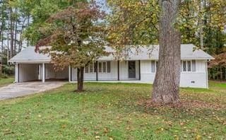 view of front of house with a front lawn and a carport