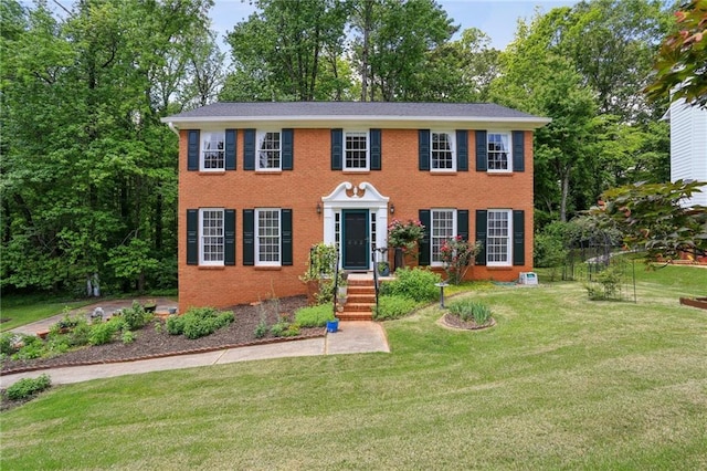 colonial inspired home featuring brick siding and a front lawn