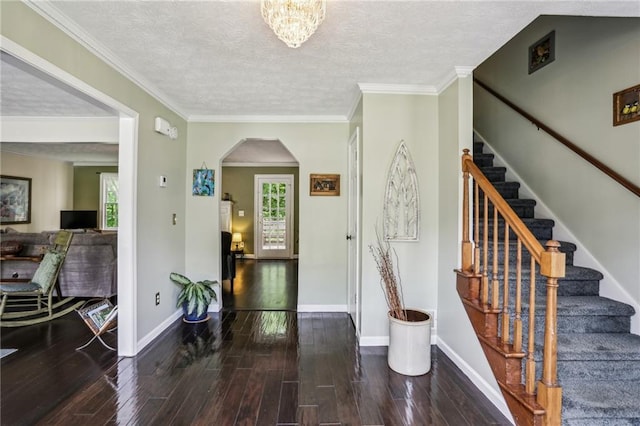 entryway featuring wood-type flooring, arched walkways, stairs, and a wealth of natural light