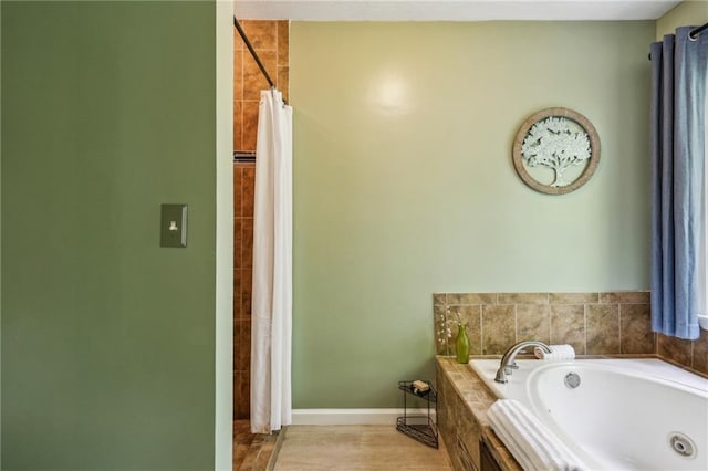 bathroom featuring a tub with jets, baseboards, and a shower with shower curtain