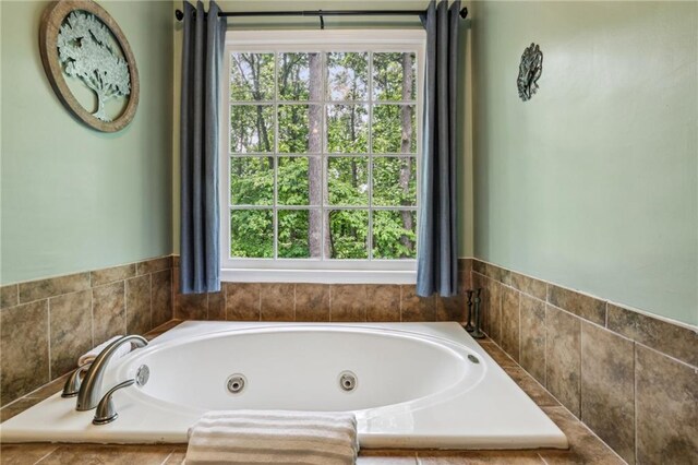 bathroom featuring plenty of natural light and a tub with jets